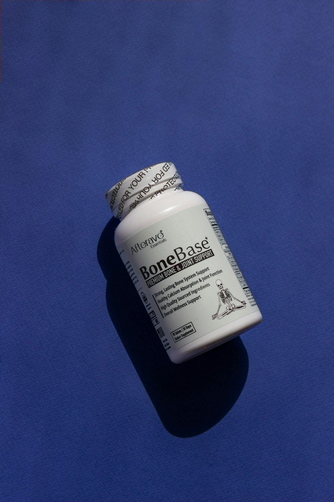 A close up of a pill bottle on a blue surface