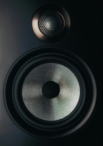 black and gray speaker on brown wooden table