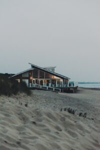 brown wooden house on beach during daytime