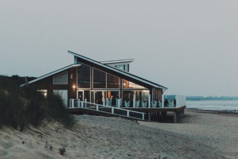 brown wooden house on beach during daytime