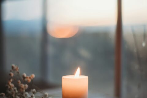 a lit candle sitting on top of a wooden table